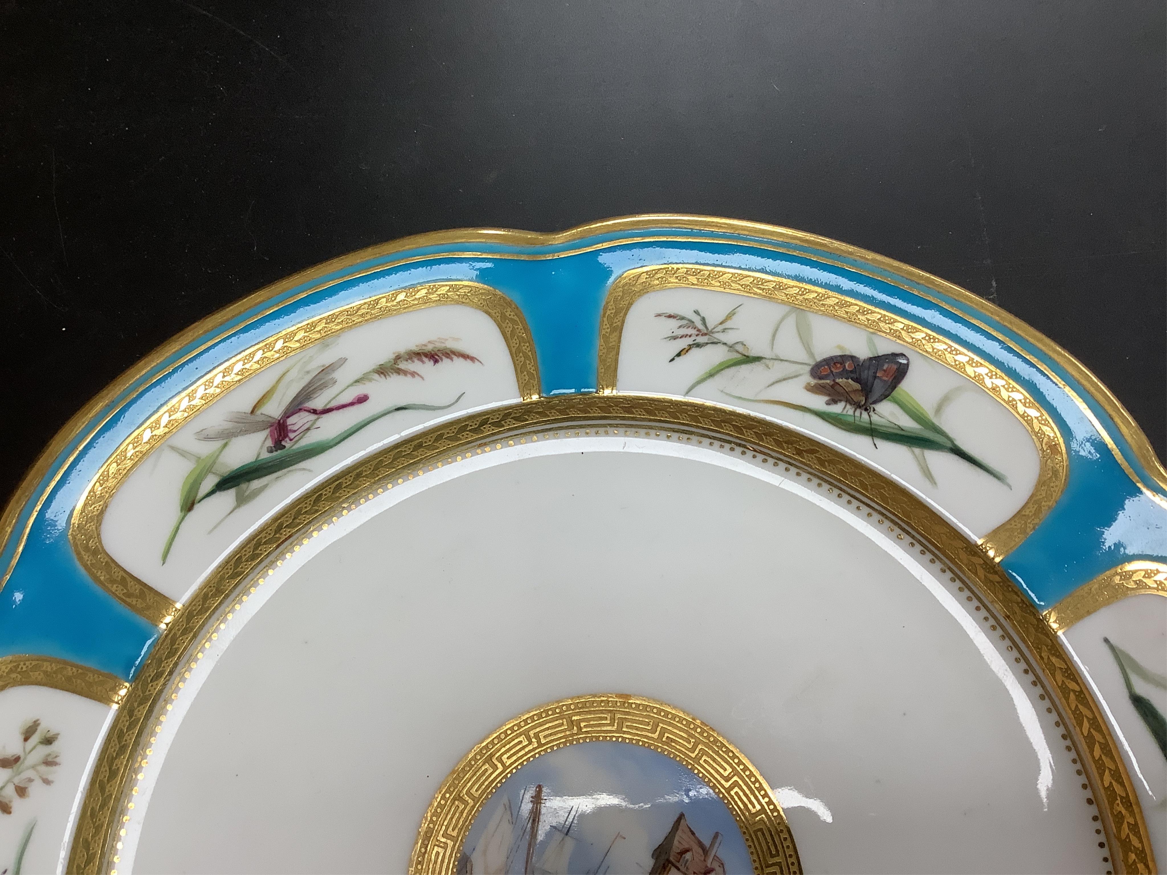 A Minton turquoise and gilt cabinet plate, decorated with butterflies and central continental harbour scene, 24cm diameter.